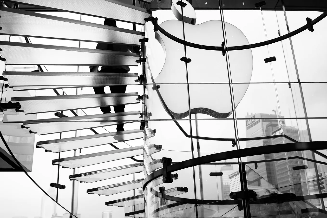 A black and white photo of a person looking at a large, complex structure of interconnected lines and nodes.