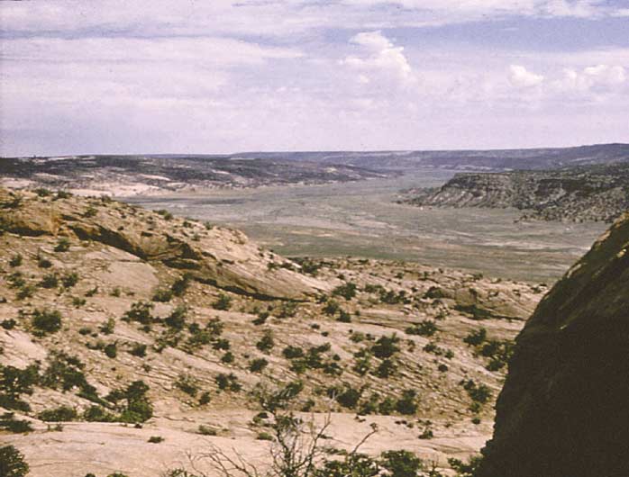 A landscape view of Long House Valley in northeastern Arizona, showing a valley floor surrounded by hills.