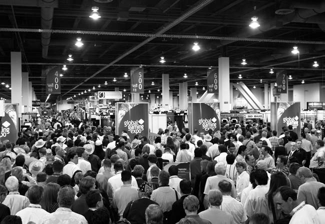 A crowded exhibition hall at the Global Gaming Exposition with overhead signs for booths 400, 500, 600, and 700.