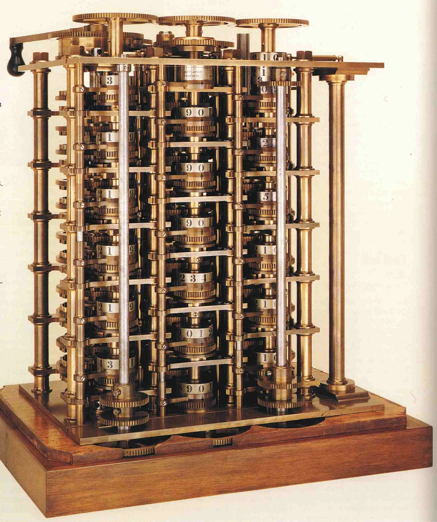 A photograph of Charles Babbage's Difference Engine, showing the intricate brass gears, columns of number wheels, and wooden base.