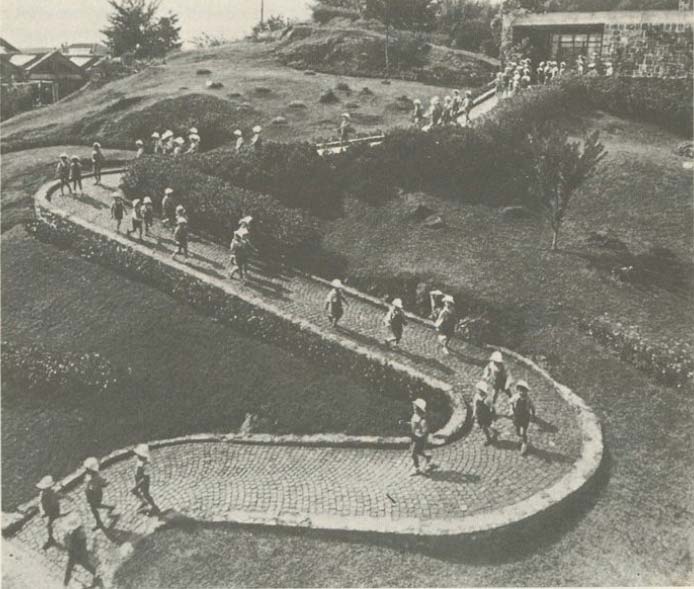 A winding path on a hillside with many people walking along it